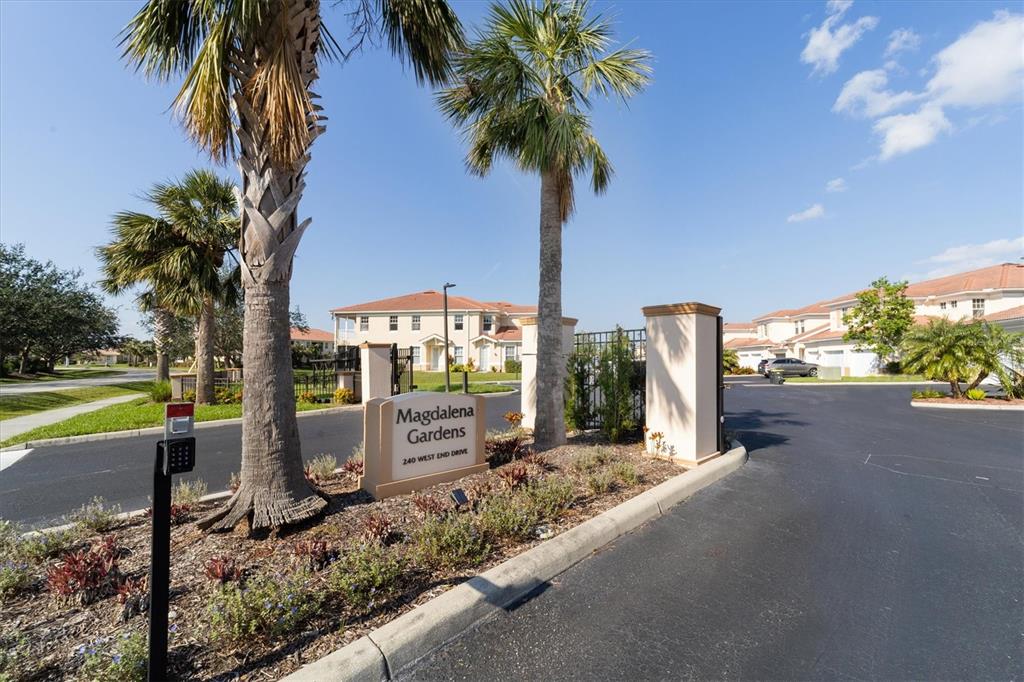 The entrance to a residential community features a sign, palm trees, and paved roads — 240 W END DRIVE UNIT 923, PUNTA GORDA, FL