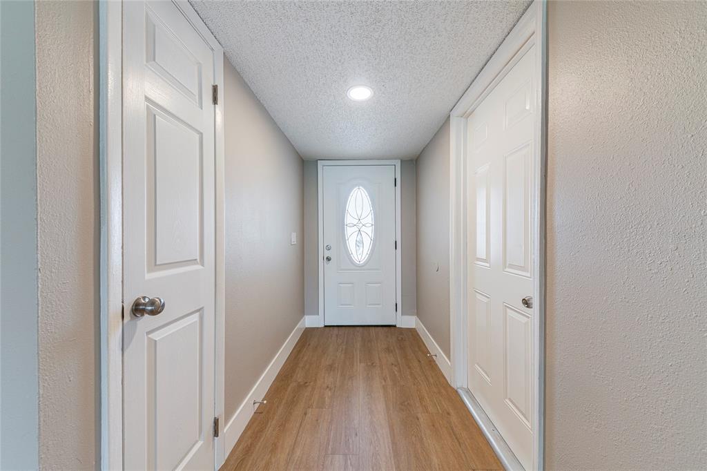 A hallway with wood-look flooring, white doors, and a front door with an oval window — 1100 CALANDA AVENUE, ORLANDO, FL