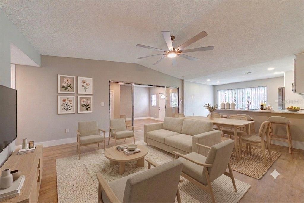 A living room with light wood floors, a beige sofa, armchairs, and a dining area — 1100 CALANDA AVENUE, ORLANDO, FL