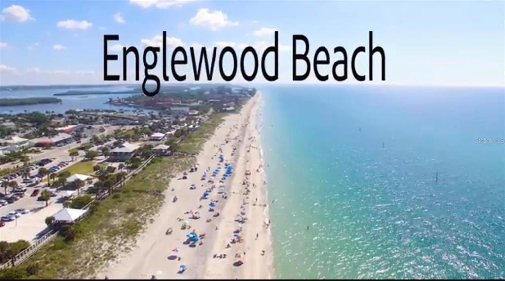 An aerial view shows Englewood Beach with a sandy shoreline, ocean, and nearby parking lots — HAMPSHIRE CIRCLE, NORTH PORT, FL