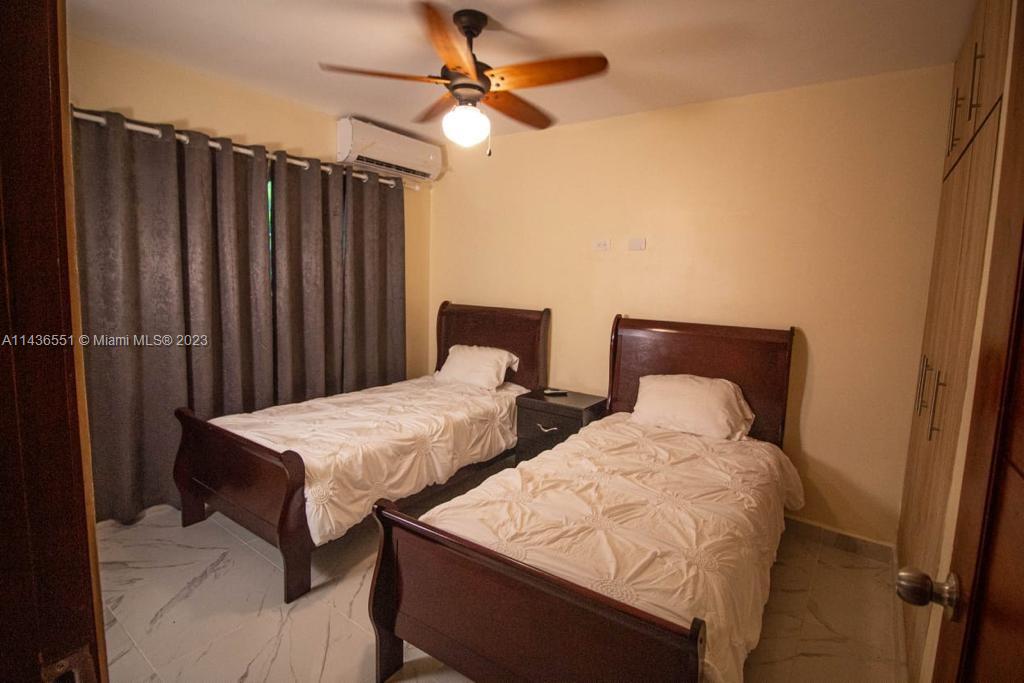A bedroom features two twin beds, a ceiling fan, and a light-colored tile floor — 1234 Carretera Sanchez # 1G, DR, DR