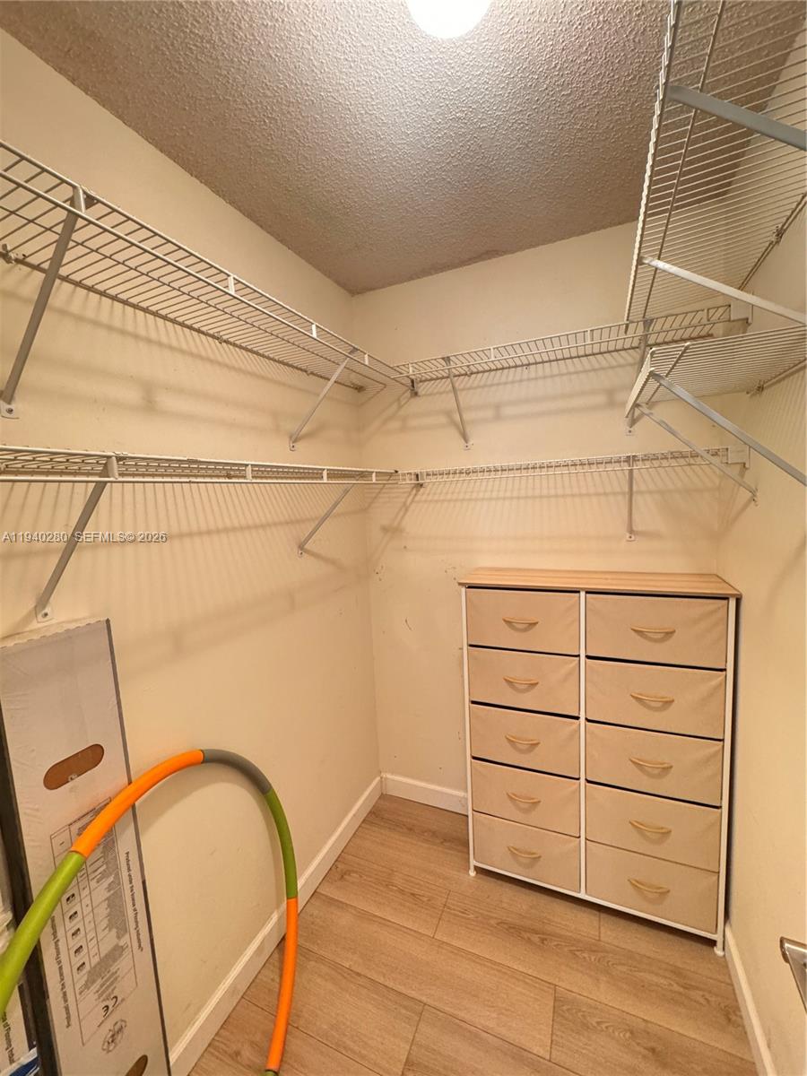 A walk-in closet features wire shelving, a ten-drawer fabric dresser, and light wood-look flooring — 1100 NW 13th St # 294D, Boca Raton FL 33486, BOCA RATON, FL