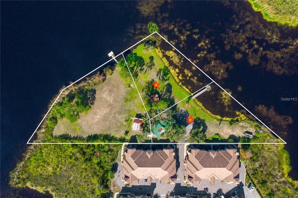 An aerial view shows a triangular waterfront lot with two buildings and two red stars — 5020 RONALD REAGAN PARKWAY, DAVENPORT, FL