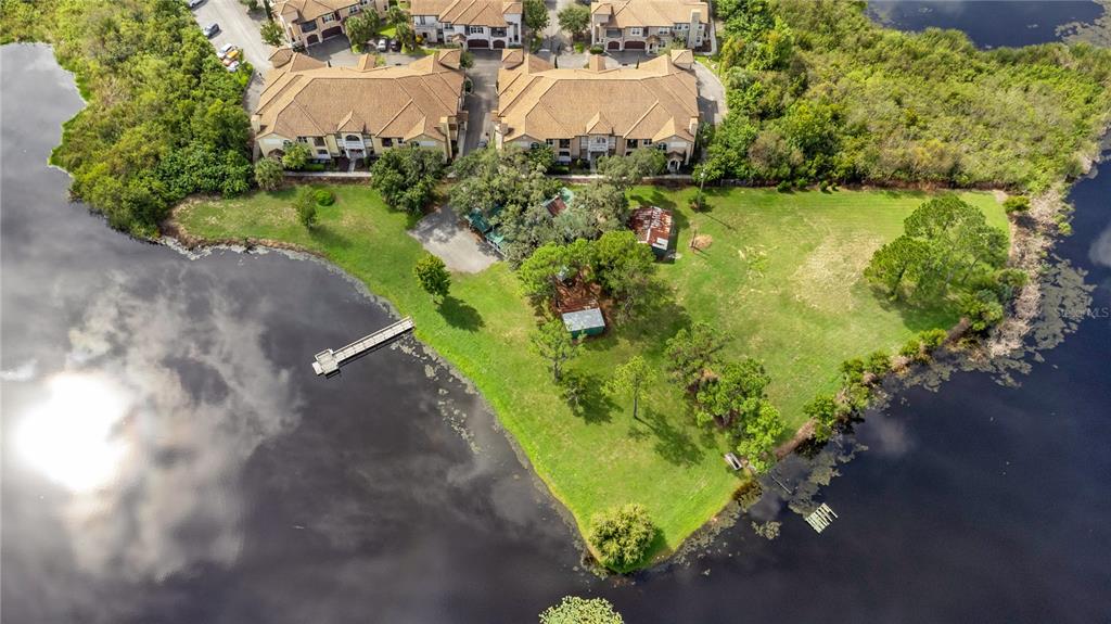 An aerial view shows a grassy waterfront lot with a dock and small structures — 5020 RONALD REAGAN PARKWAY, DAVENPORT, FL