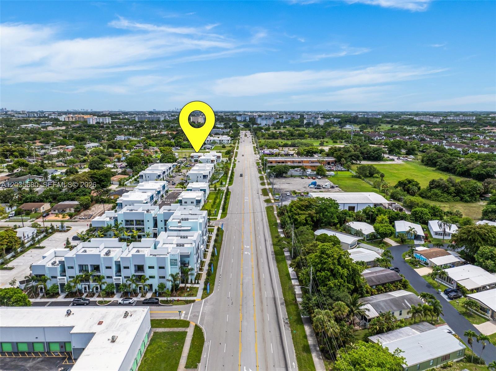 This aerial view shows a multi-story residential complex beside a road with surrounding suburban development — NW 31st Ave, Pompano Beach FL 33069, POMPANO BEACH, FL