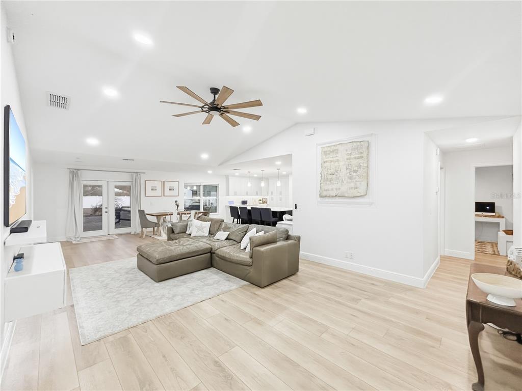 A bright, open-concept living room features light wood flooring, a sectional sofa, and recessed lighting — 2285 FOX WOOD COURT, ST CLOUD, FL