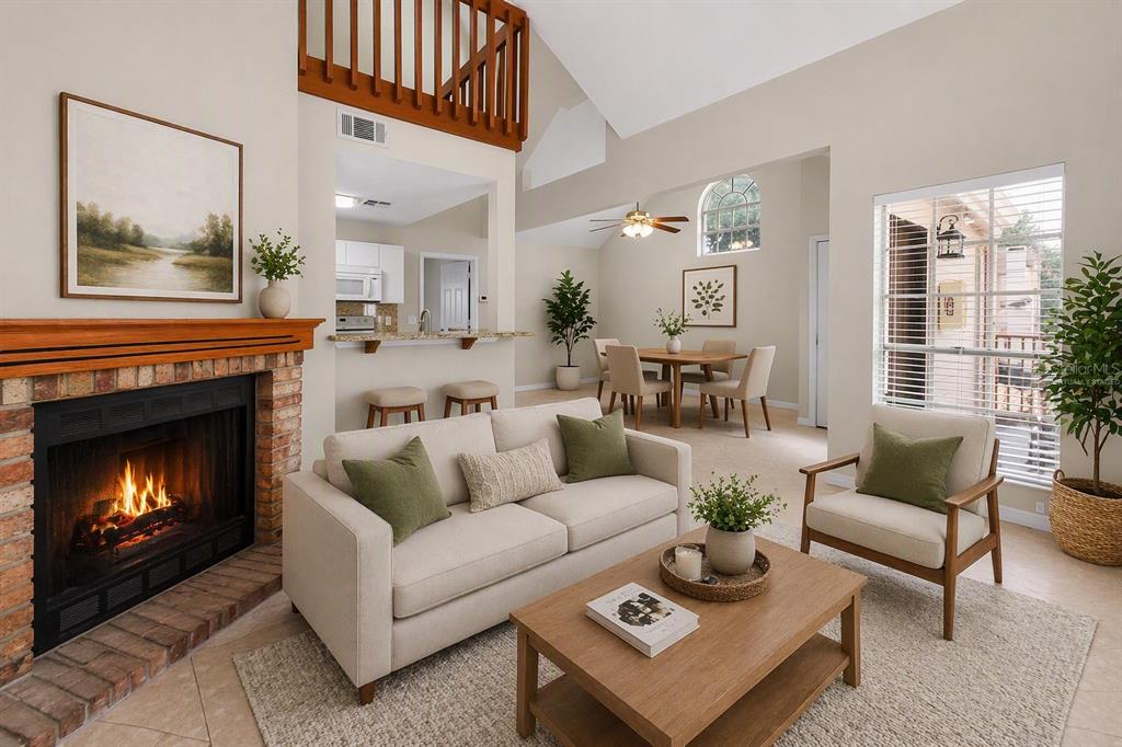 A living room with a fireplace, sofa, armchair, and an open view to the dining area — 605 YOUNGSTOWN PARKWAY UNIT 30, ALTAMONTE SPRINGS, FL