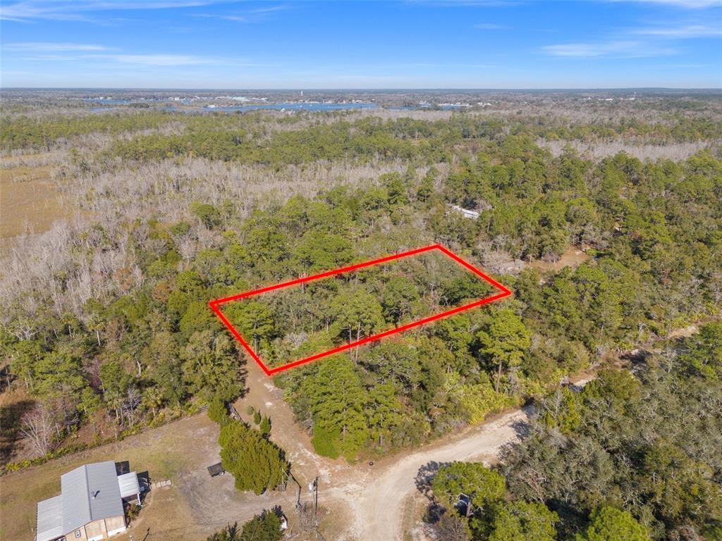 An aerial view shows a rectangular plot of land outlined in red amidst wooded terrain — 419 N VESPER POINT, CRYSTAL RIVER, FL