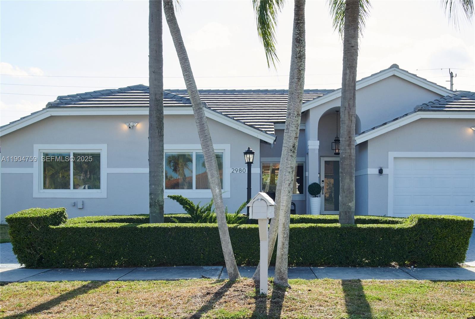 A single-story house with a tiled roof, palm trees, and a manicured hedge in front — 2980 SW 141st Ct, Miami FL 33175, MIAMI, FL
