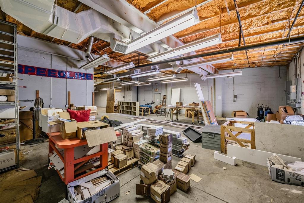 An unfinished industrial warehouse space features exposed ceiling joists, spray foam insulation, and concrete floors — 2902 W CHESTNUT STREET, TAMPA, FL