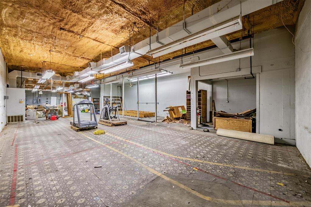 An unfinished commercial space features a textured ceiling, fluorescent lighting, and patterned tile flooring — 2902 W CHESTNUT STREET, TAMPA, FL