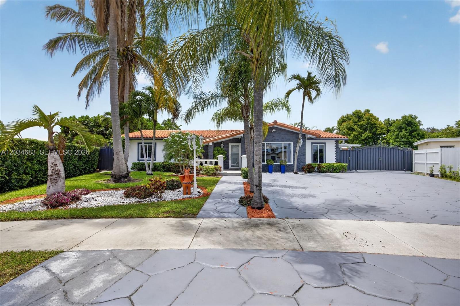 A single-story house features a gray stone driveway, palm trees, and a terracotta tile roof — 12121 SW 107th St, Miami FL 33186, MIAMI, FL