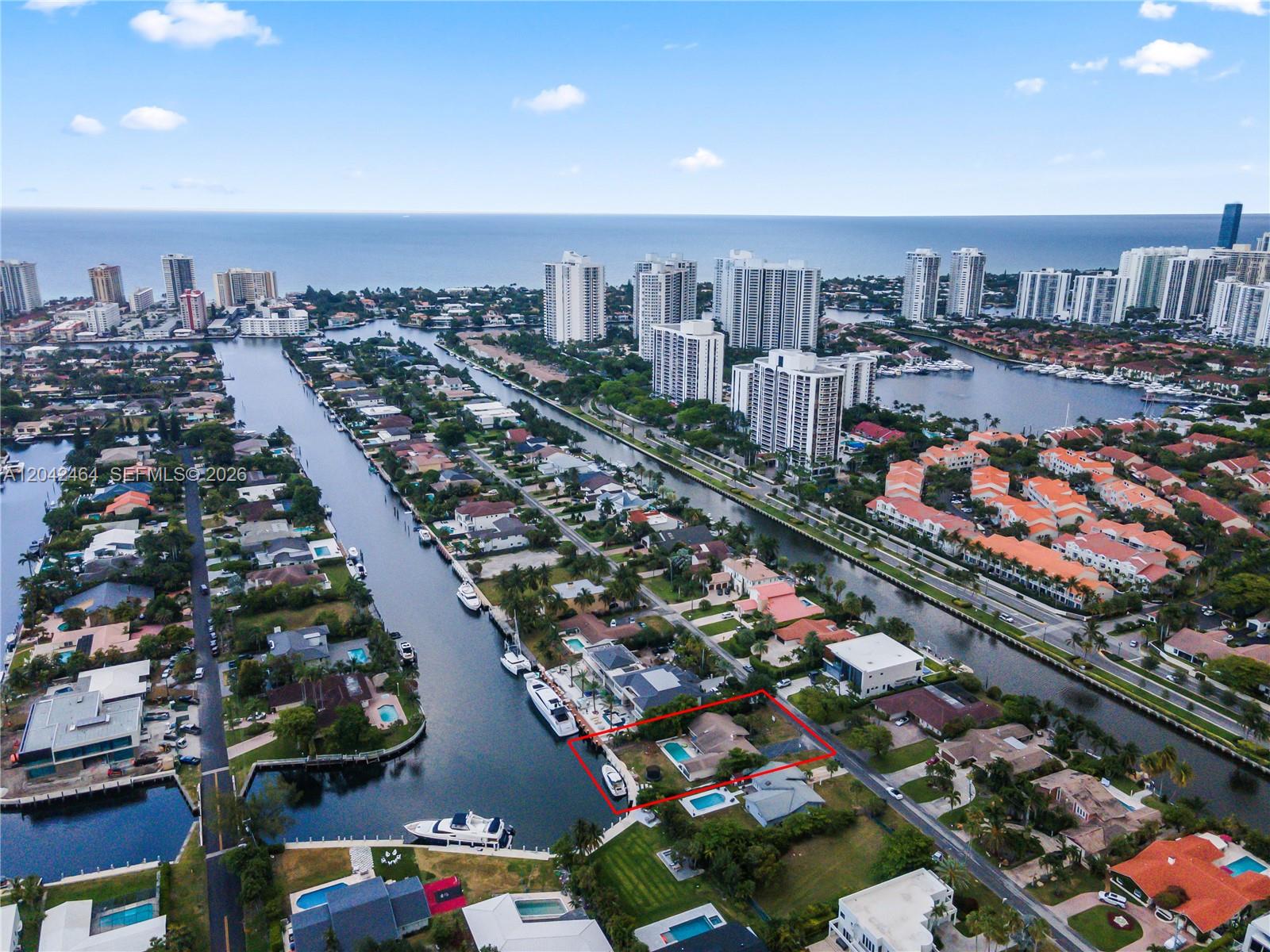 An aerial view shows a waterfront house with a pool and boat dock in Florida — 496 Holiday Dr, Hallandale Beach FL 33009, HALLANDALE BEACH, FL