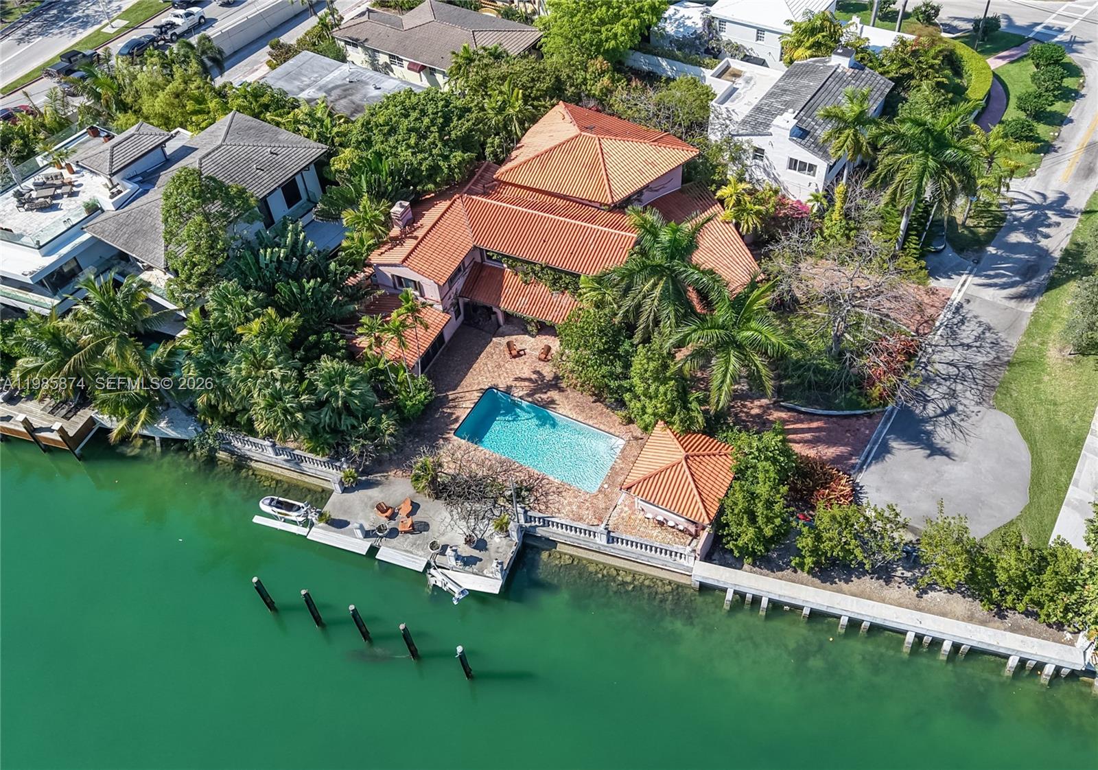 An aerial view shows a waterfront house with a red-tiled roof, pool, and private dock — 3310 Garden Ave, Miami Beach FL 33140, MIAMI BEACH, FL