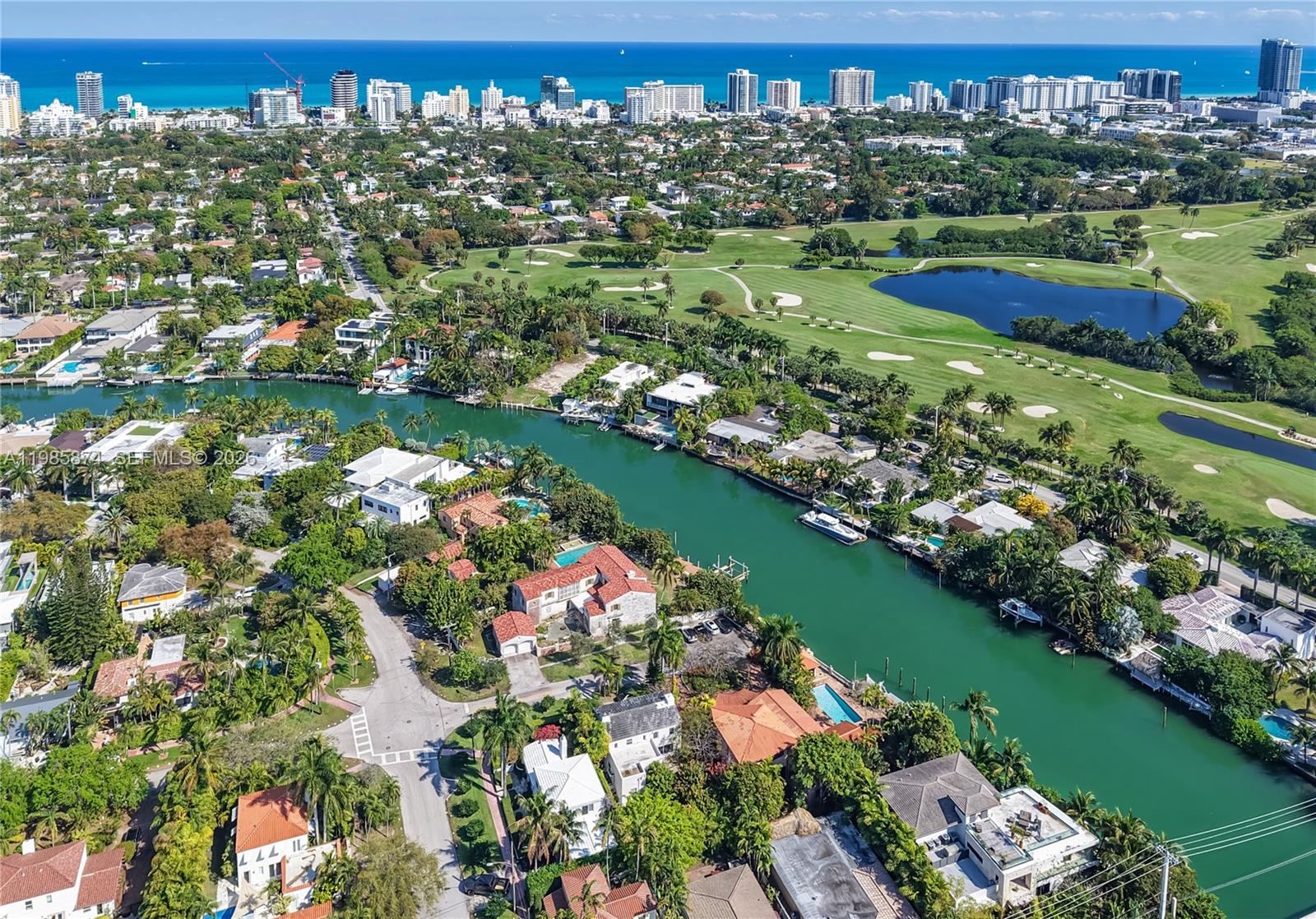 An aerial view shows a canal winding through a residential neighborhood next to a golf course — 3310 Garden Ave, Miami Beach FL 33140, MIAMI BEACH, FL