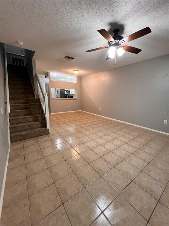 A living room with tile flooring, a staircase, and a ceiling fan — 8674 HUNTERS KEY CIRCLE, TAMPA, FL