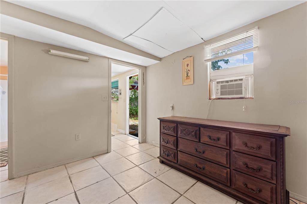 A room with tiled floors, a wooden dresser, and a doorway leading to the outdoors — 2615 W COMANCHE AVENUE, TAMPA, FL