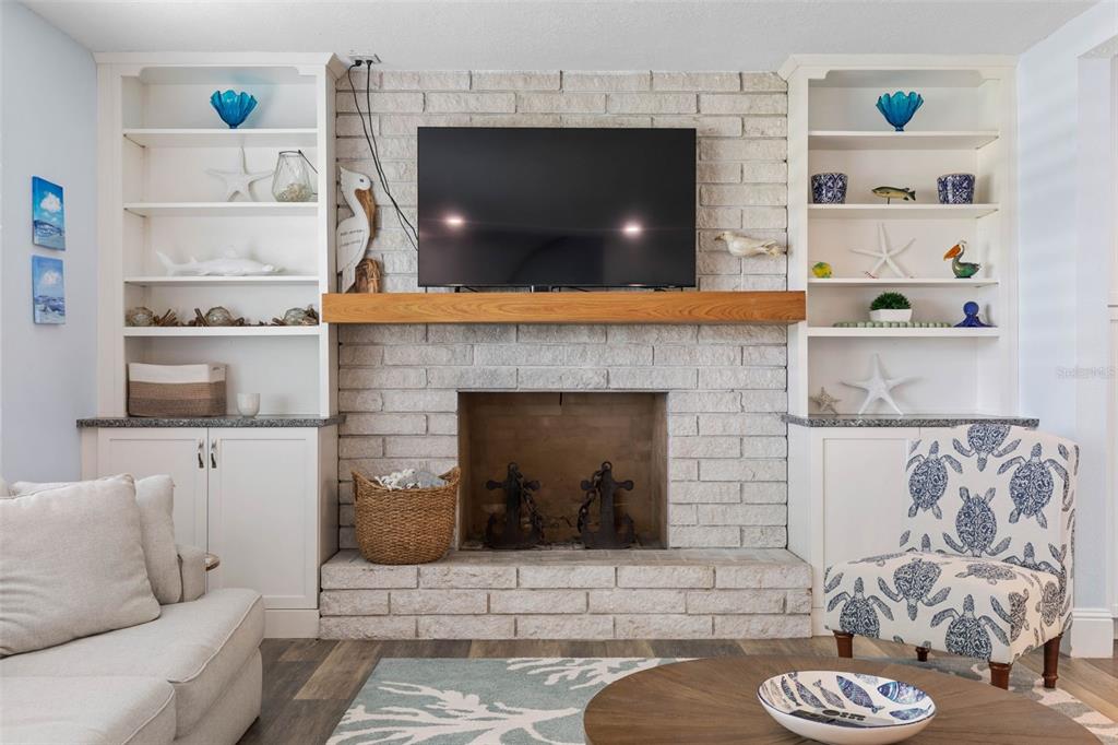 A living room features a white brick fireplace with a wood mantel and built-in shelving — 26 OCEAN VISTA LANE, PALM COAST, FL