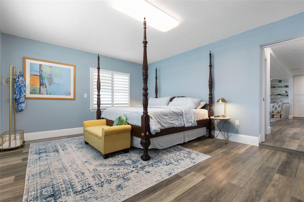 A bedroom features a four-poster bed, a yellow bench, and a blue patterned area rug — 26 OCEAN VISTA LANE, PALM COAST, FL