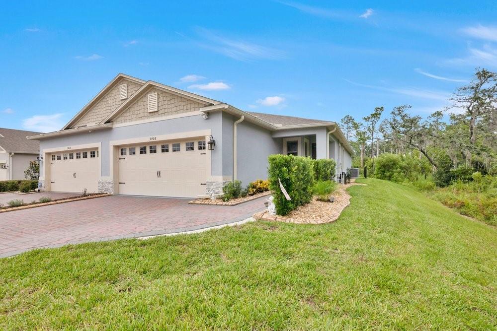A single-story house with a two-car garage, a paved driveway, and a grassy lawn — 3408 TWIN FLOWER COURT, CLERMONT, FL