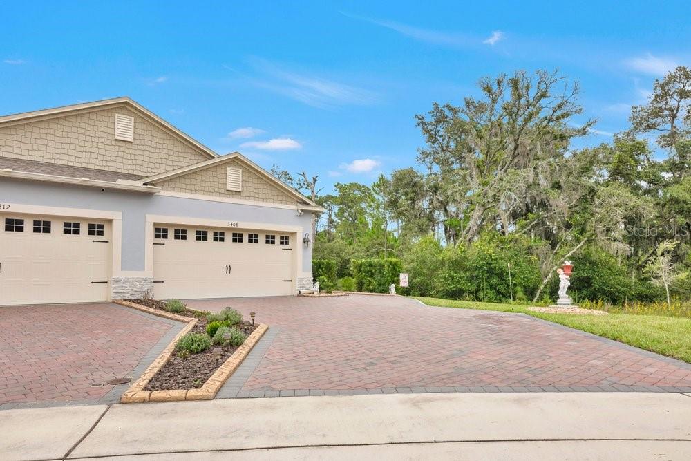 The exterior of a suburban house features a two-car garage and a paved driveway — 3408 TWIN FLOWER COURT, CLERMONT, FL