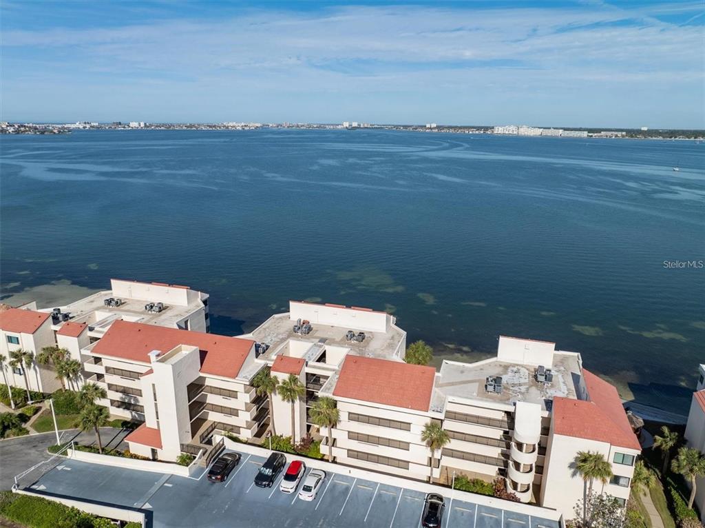 An aerial view of a multi-story waterfront condominium complex with a parking lot — 5633 PUERTA DEL SOL BOULEVARD S UNIT 307, ST PETERSBURG, FL