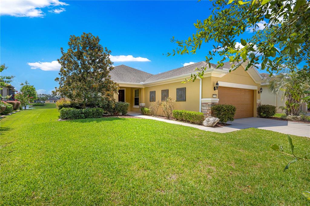 A single-story yellow house with a two-car garage and a large front lawn — 9530 SW 70TH LOOP, OCALA, FL