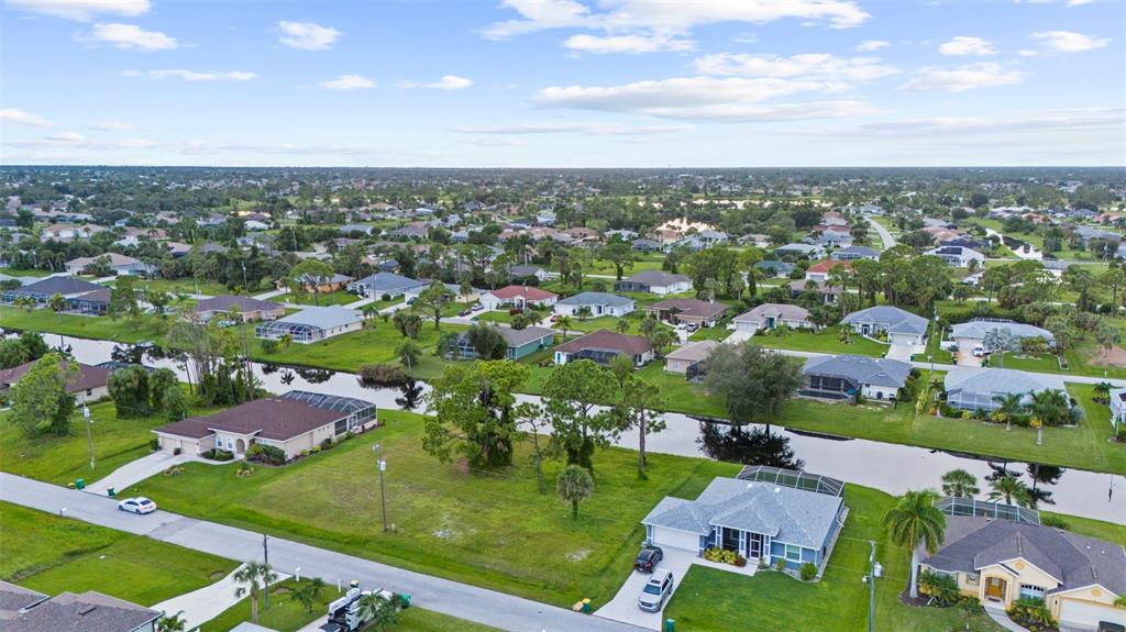 An aerial view shows suburban houses with swimming pools and a canal in a residential neighborhood — 29 MARKER ROAD, ROTONDA WEST, FL