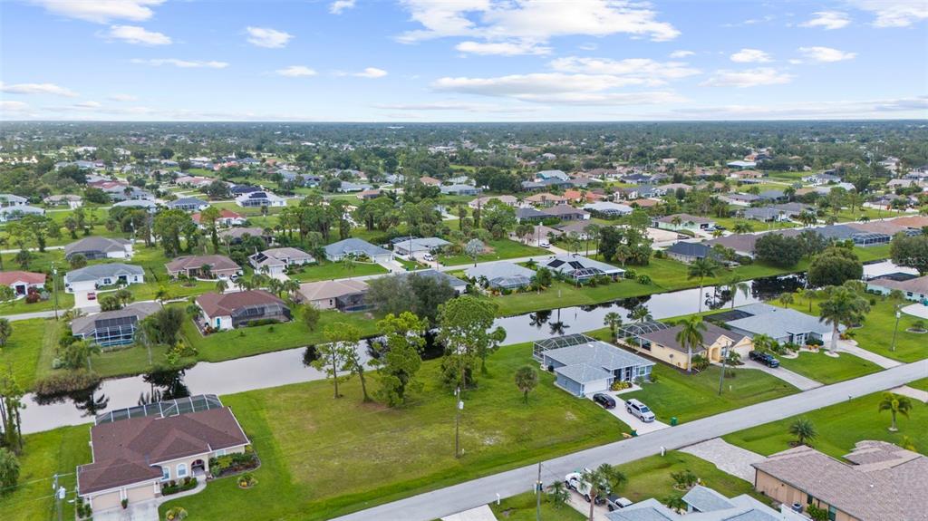 An aerial view of a suburban neighborhood featuring houses with pools along a canal — 29 MARKER ROAD, ROTONDA WEST, FL