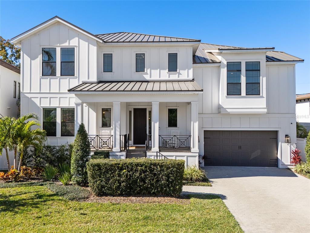 A two-story white farmhouse with a metal roof, front porch, and attached garage — 478 BOSPHOROUS AVENUE, TAMPA, FL
