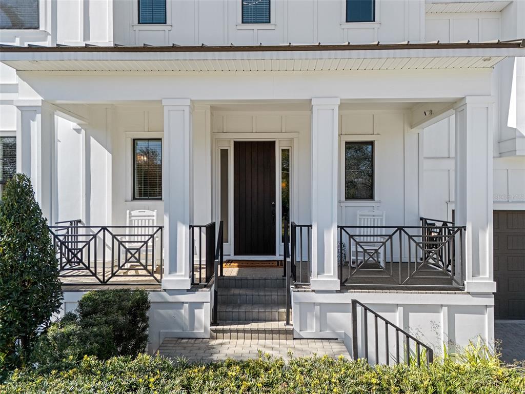 A white house exterior features a covered front porch with black railings and a dark door — 478 BOSPHOROUS AVENUE, TAMPA, FL