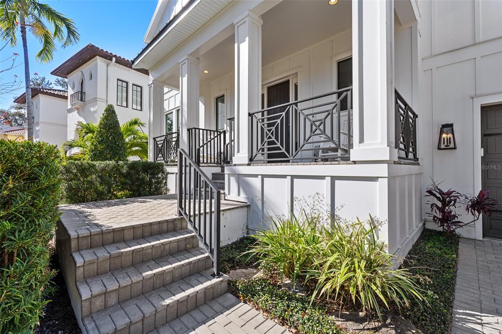 A white house exterior features a front porch with black railings and stone steps — 478 BOSPHOROUS AVENUE, TAMPA, FL