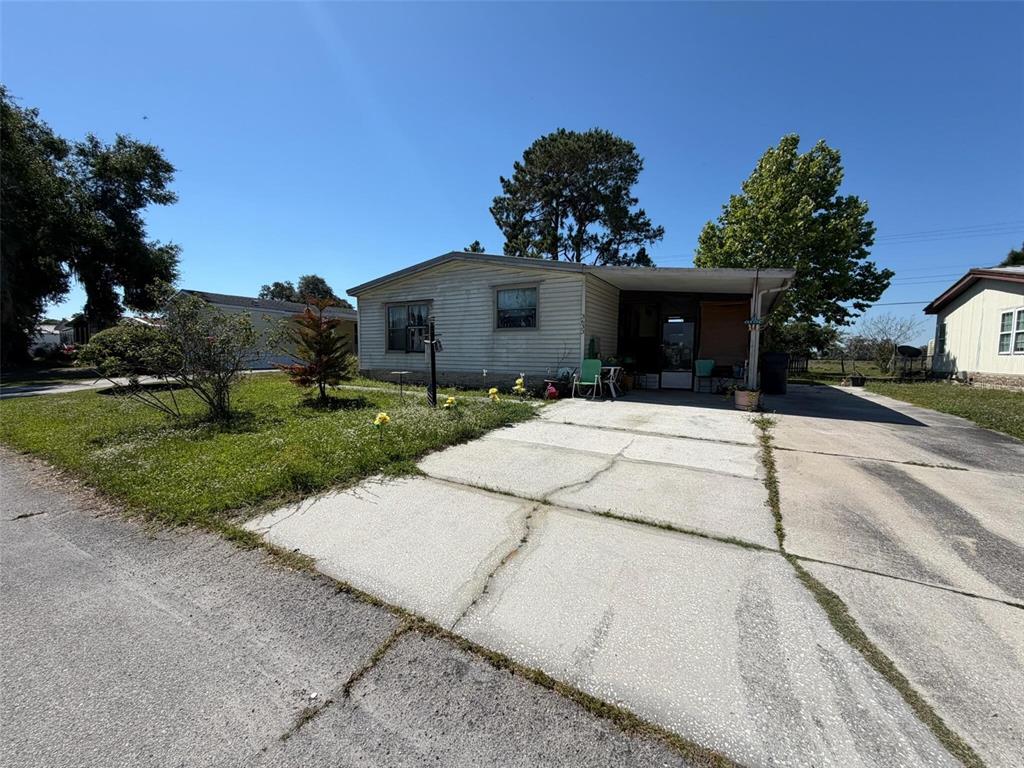 A single-story mobile home with a concrete driveway and a small covered front porch — 3633 LAZY LAKE DRIVE S UNIT 3, LAKELAND, FL