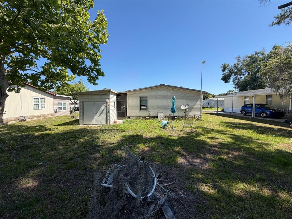 The exterior of a single-story mobile home with a shed and a grassy yard — 3633 LAZY LAKE DRIVE S UNIT 3, LAKELAND, FL