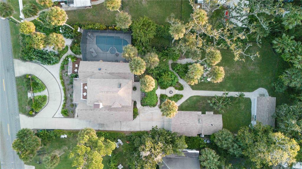 An aerial view shows a house with a pool, landscaped yard, and detached garage — 4946 HALIFAX DRIVE, PORT ORANGE, FL