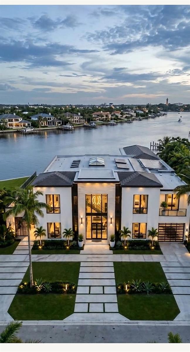 An aerial view of a modern two-story waterfront home with a paved driveway and landscaping — 965 Marlin Drive, Jupiter FL 33458, JUPITER, FL