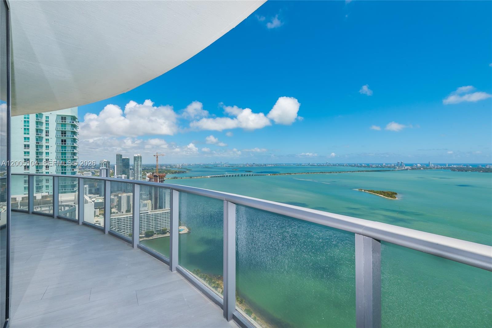 A high-rise balcony with a glass railing overlooks a bay, a bridge, and city buildings — 488 NE 18th St # 4515, Miami FL 33132, MIAMI, FL