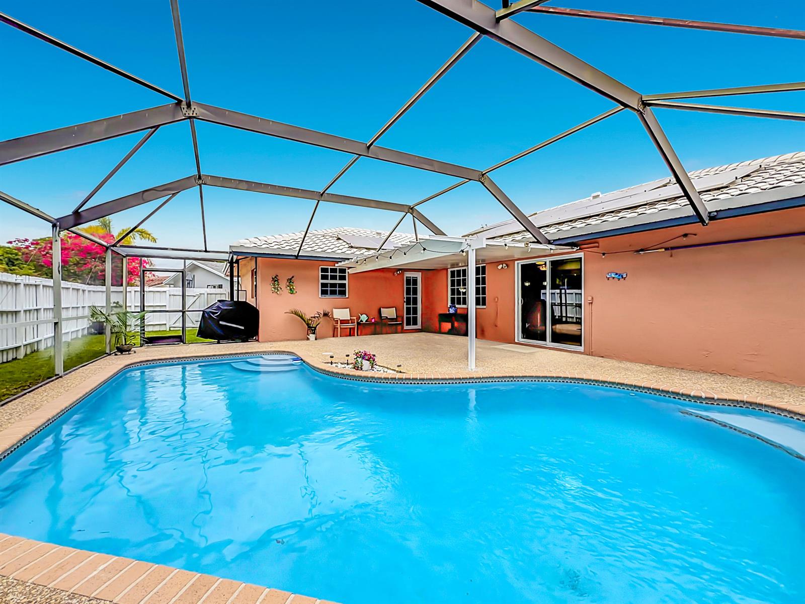 A swimming pool sits on a patio enclosed by a metal screen cage — 851 E Plantation Circle, Plantation FL 33324, PLANTATION, FL