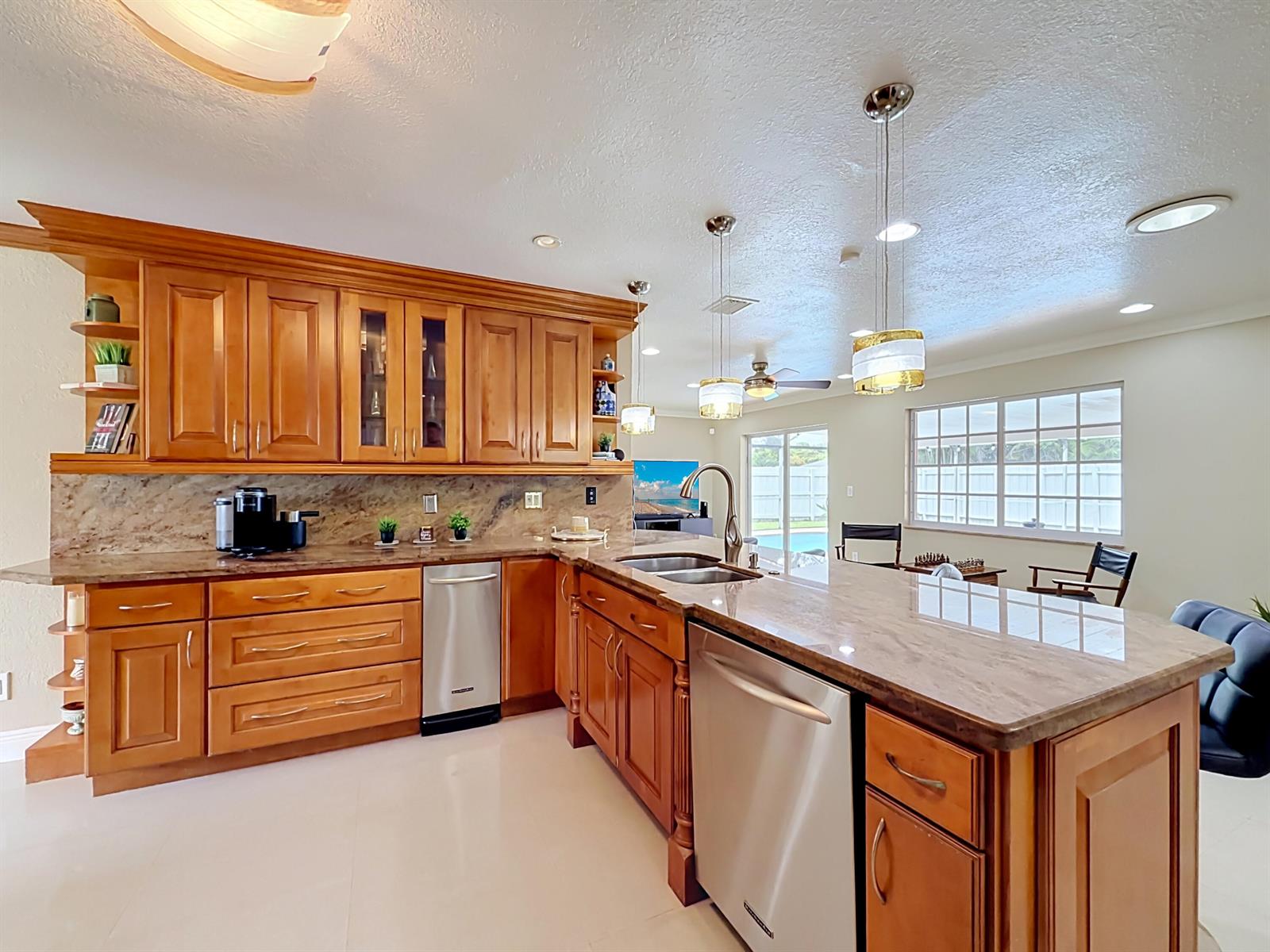 A kitchen with wood cabinets, granite countertops, stainless steel appliances, and pendant lighting — 851 E Plantation Circle, Plantation FL 33324, PLANTATION, FL
