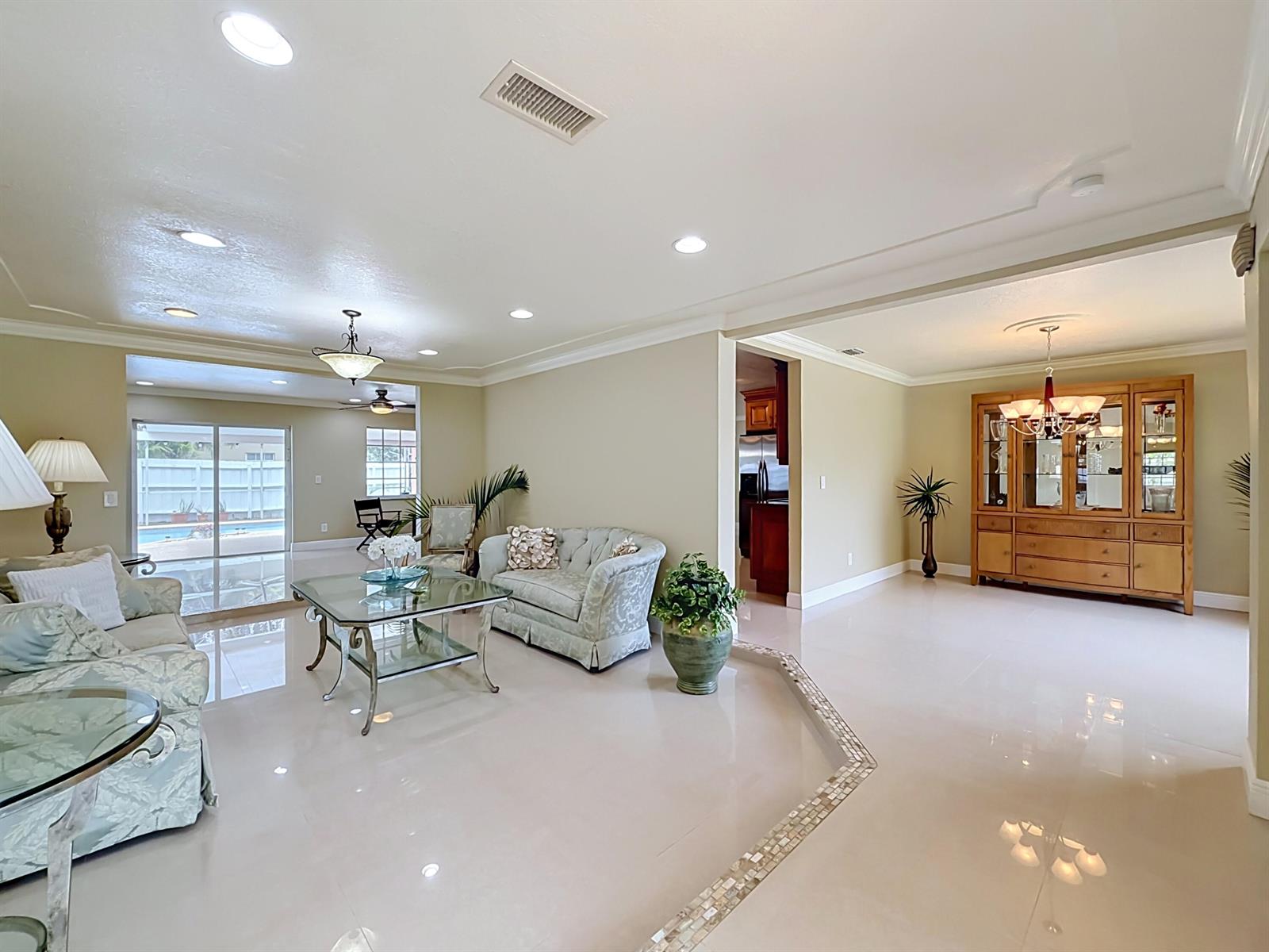 A living room with light tile floors, a glass coffee table, and a dining hutch — 851 E Plantation Circle, Plantation FL 33324, PLANTATION, FL