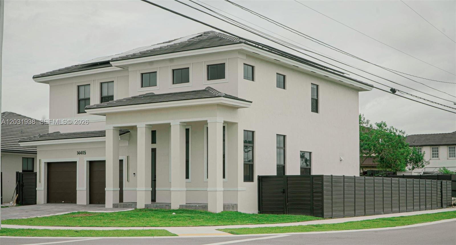 A two-story modern house with a light-colored stucco exterior and a dark-tiled roof — 14405 SW 13th Ter, Miami FL 33184, MIAMI, FL