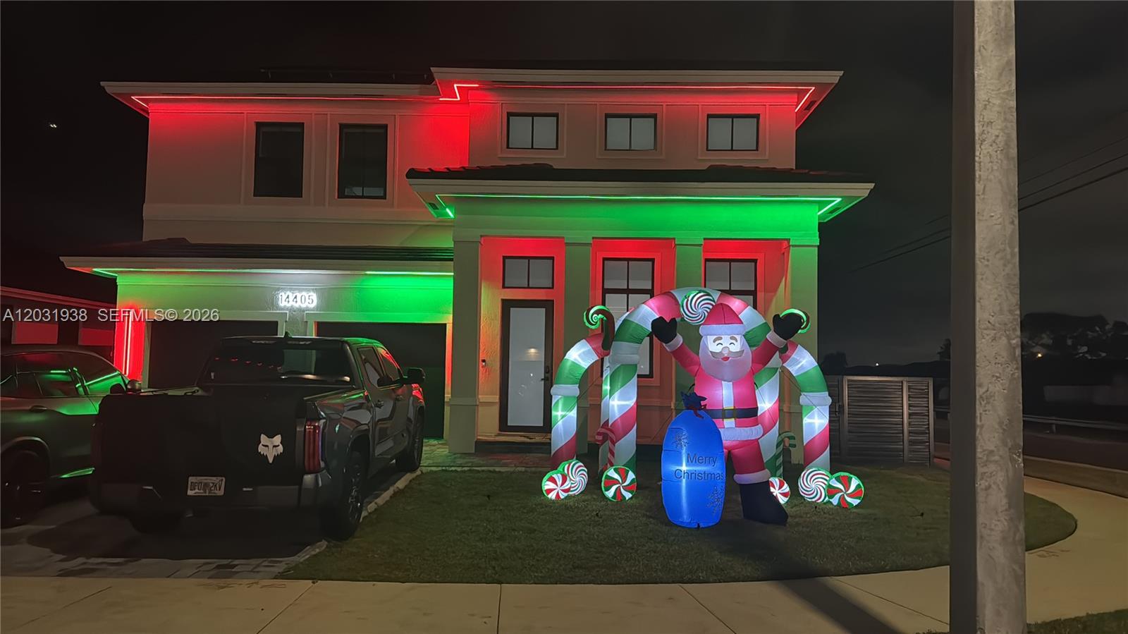 A two-story house exterior is decorated with red and green lights and a Santa inflatable — 14405 SW 13th Ter, Miami FL 33184, MIAMI, FL
