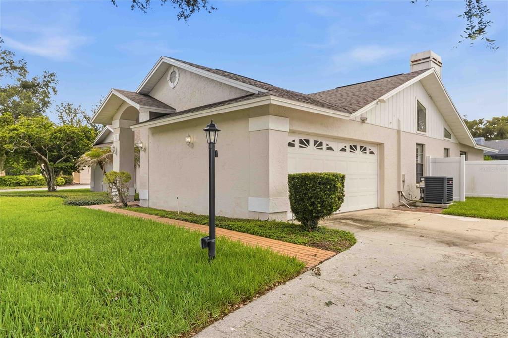 A beige single-story house with a two-car garage, a brick walkway, and a grassy lawn — 2110 LAINDALE # PLACE, VALRICO, FL