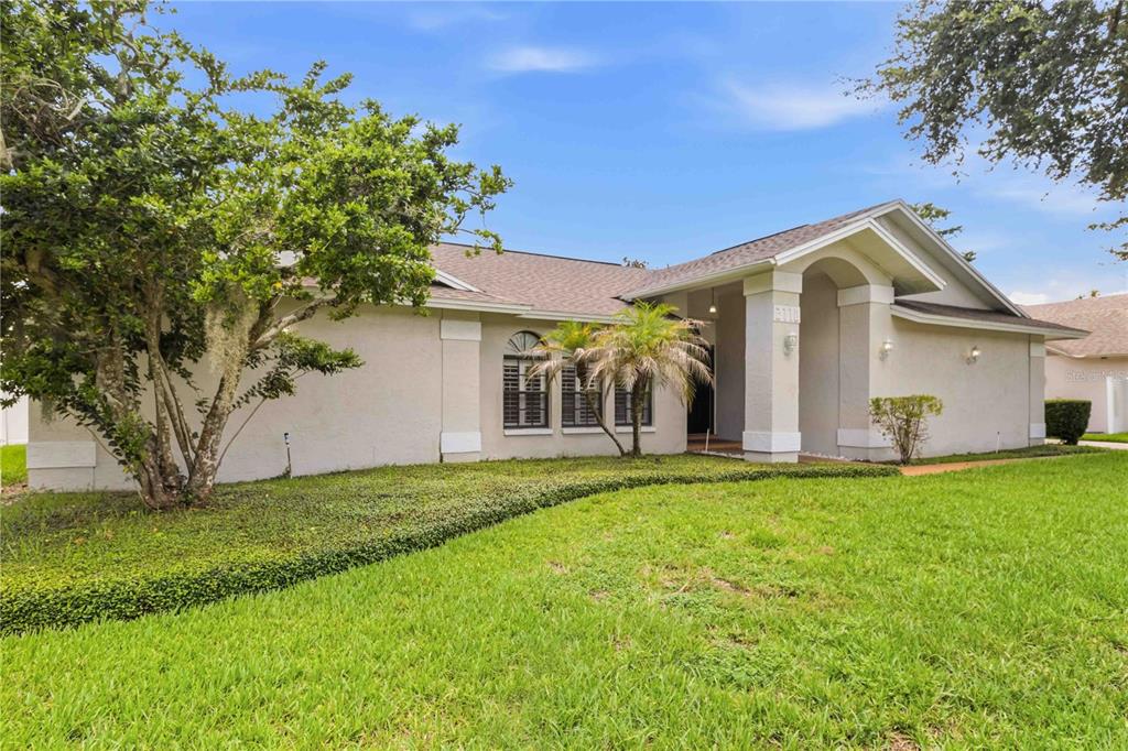 A single-story house with a beige stucco exterior, a covered entryway, and a front lawn — 2110 LAINDALE # PLACE, VALRICO, FL
