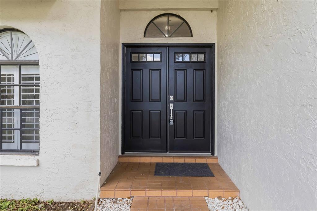 A front entryway features double black doors with glass panels and a semi-circular transom window — 2110 LAINDALE # PLACE, VALRICO, FL