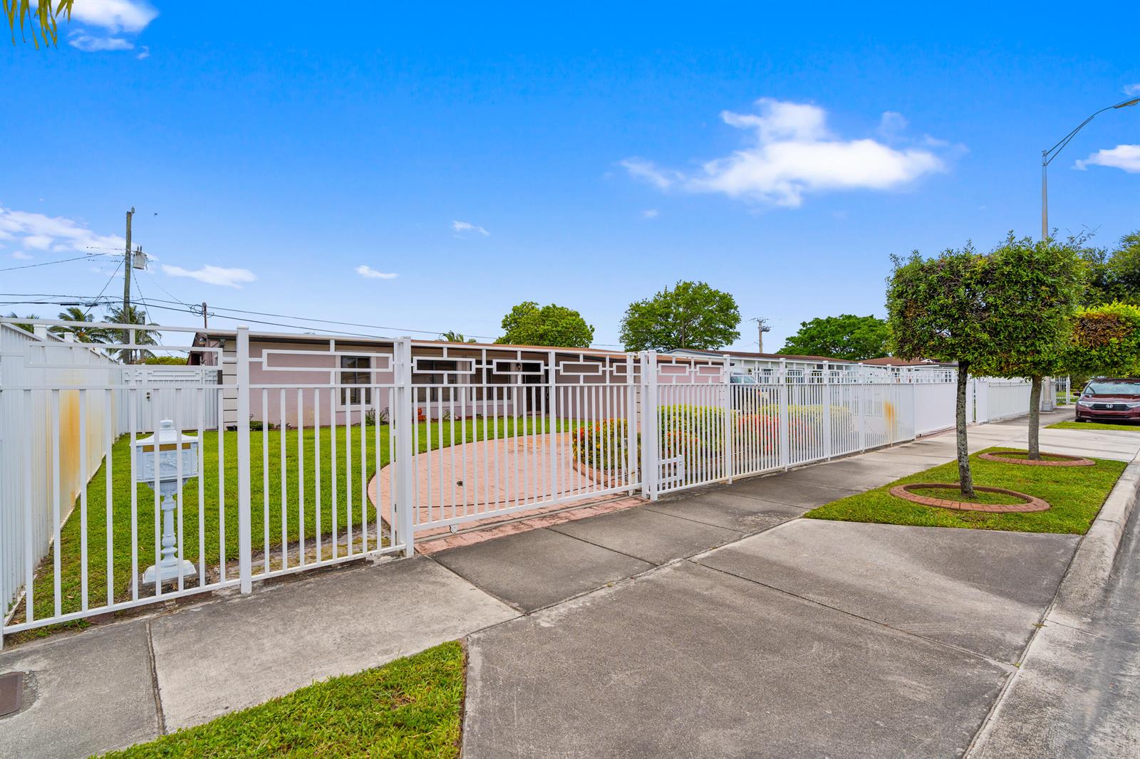 A single-story house with a white fence and a paved front yard — 6160 W 14th Avenue, Hialeah FL 33012, HIALEAH, FL