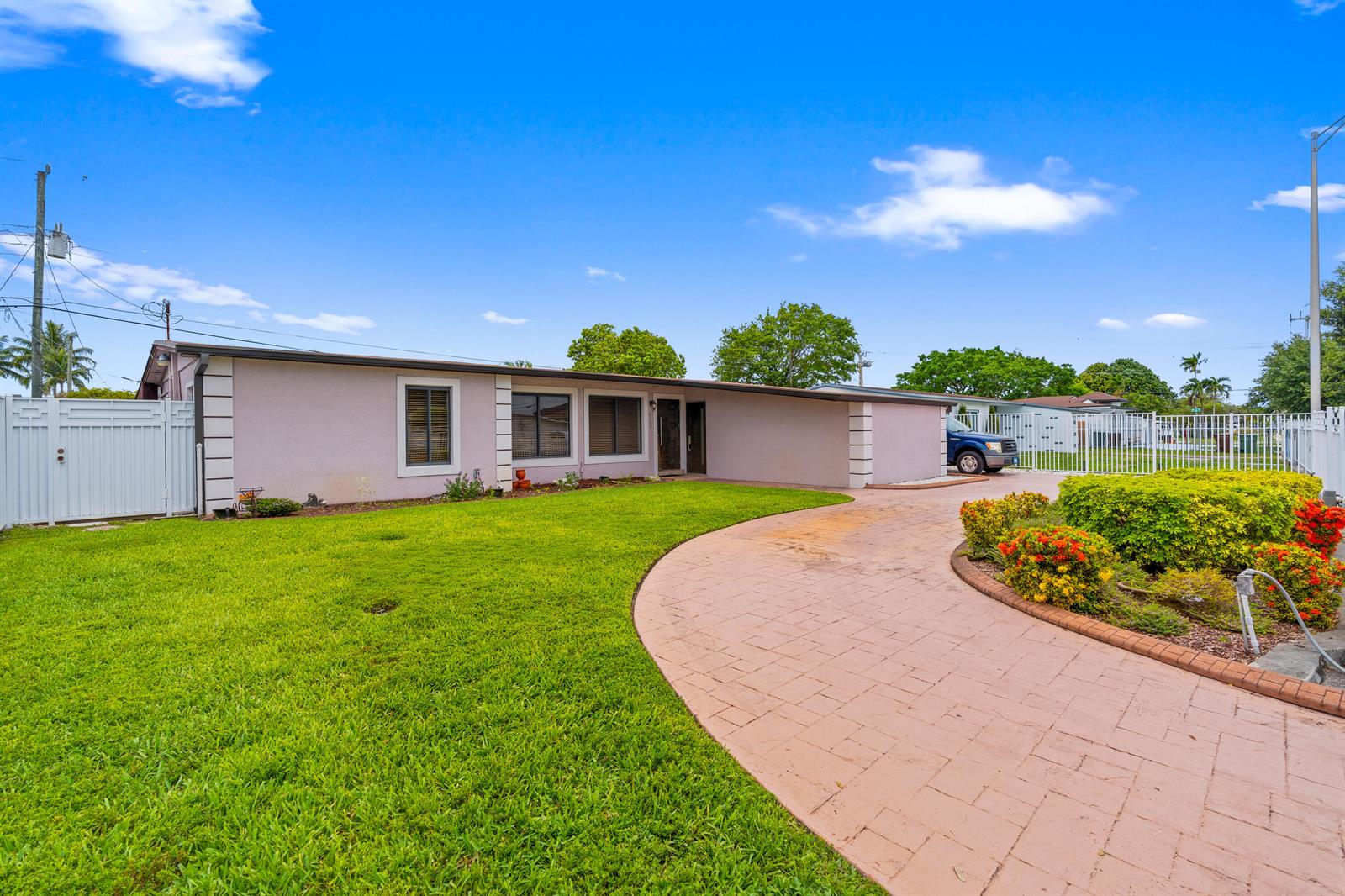 A single-story house with a light-colored exterior, a curved paver driveway, and a green lawn — 6160 W 14th Avenue, Hialeah FL 33012, HIALEAH, FL
