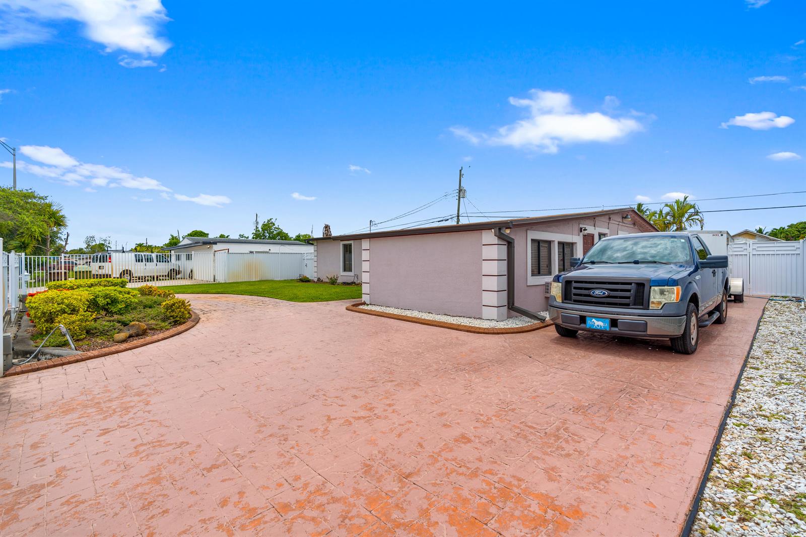 A blue Ford pickup truck is parked on a stamped concrete driveway beside a house — 6160 W 14th Avenue, Hialeah FL 33012, HIALEAH, FL