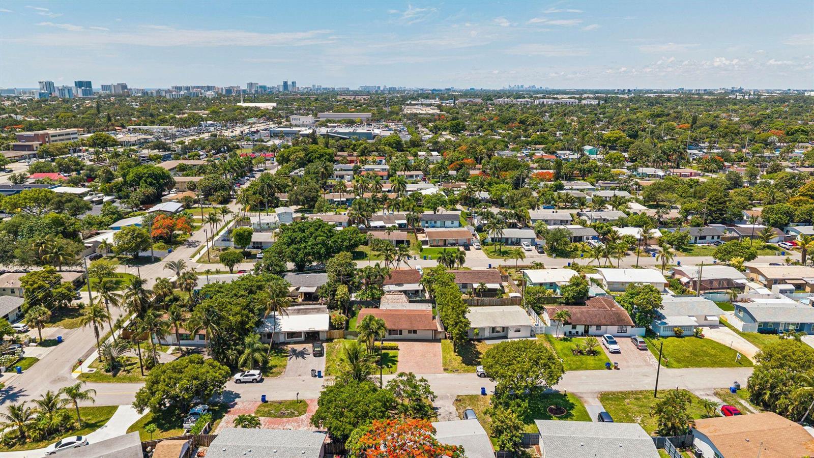 An aerial view of a suburban neighborhood featuring single-family homes, lush trees, and paved streets — 1660 NE 31st Court, Pompano Beach FL 33064, POMPANO BEACH, FL