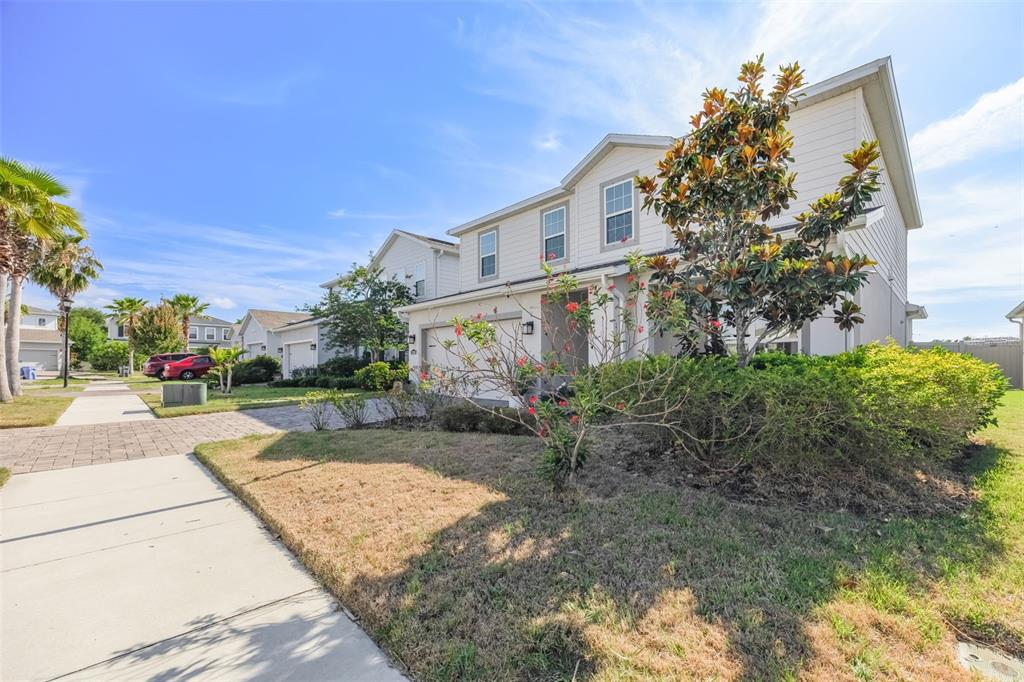A two-story suburban house with light siding, a paved driveway, and a landscaped front yard — 12349 BLUE PACIFIC DRIVE, RIVERVIEW, FL